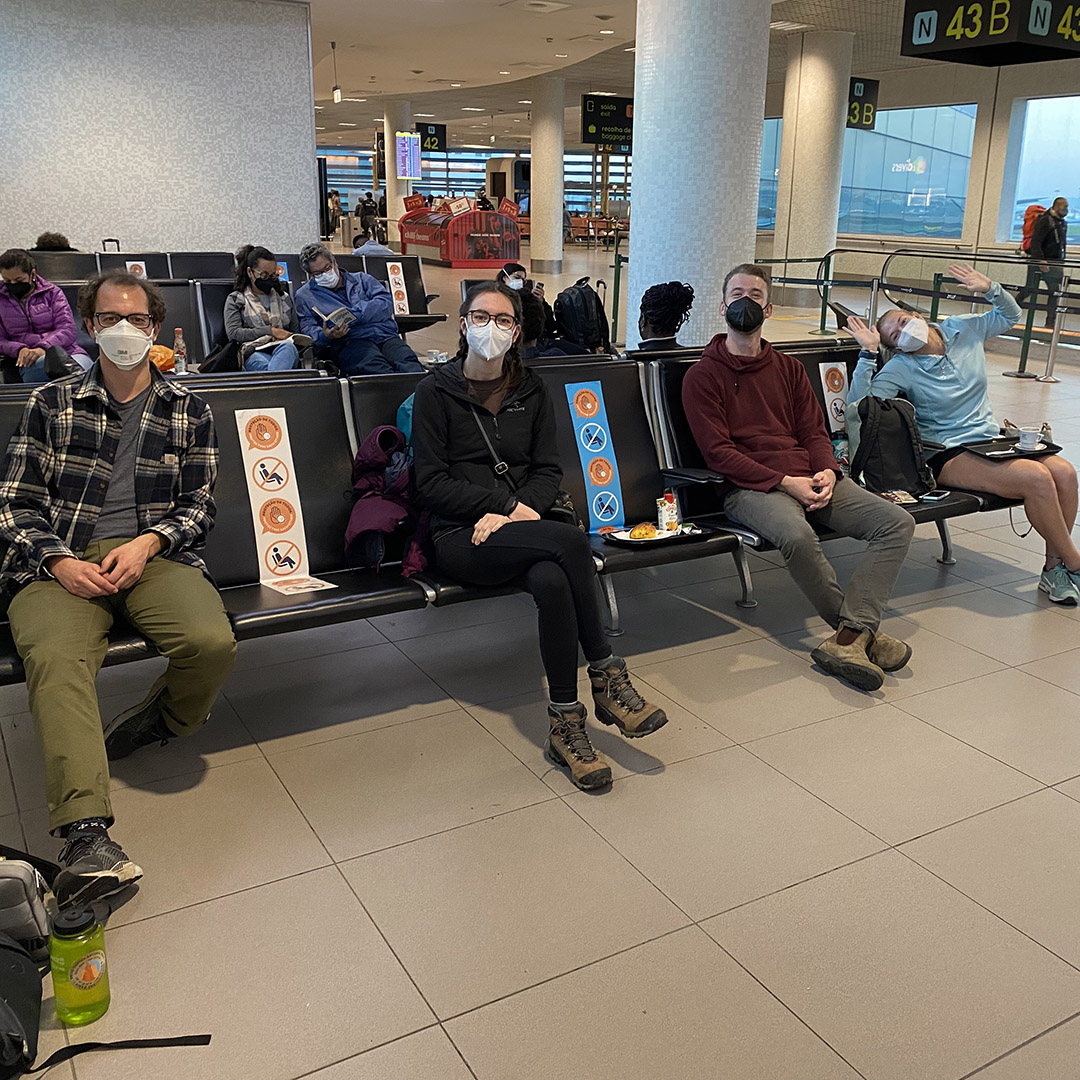 Zach, Jade, Sam, and Sierra, members of the science team, demonstrate correct social distancing and masking procedures in the Lisbon airport.