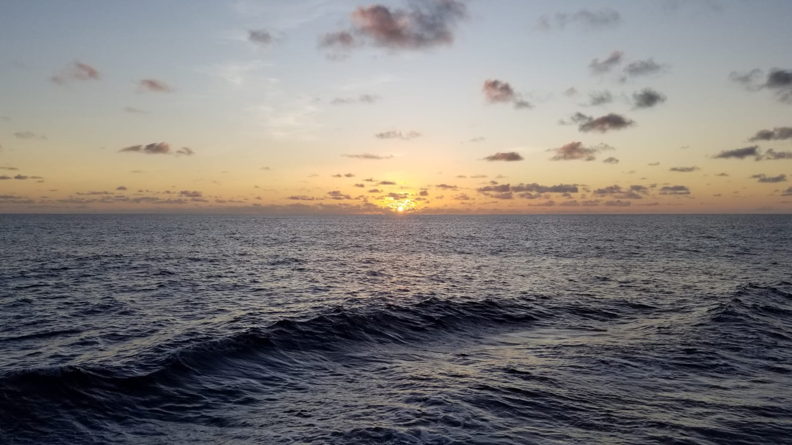 Sunrise at sea with some rolling waves, earning us a “turbulent” journey. Photo by Sidney Wayne.