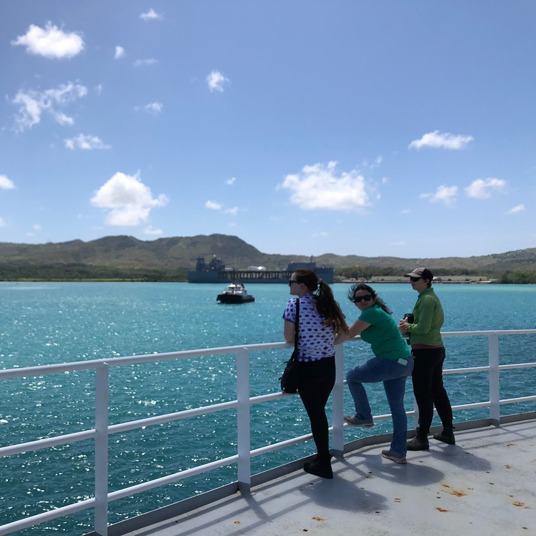 Saying goodbye to Guam as we sail out of the harbor. Featuring Sara Gray, Abby Tinari, and Steffi O'Daly (left to right). Photo by Mariana Aguirre.