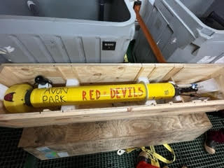 Yellow float lies in a crate with the word "Red Devils" written on it