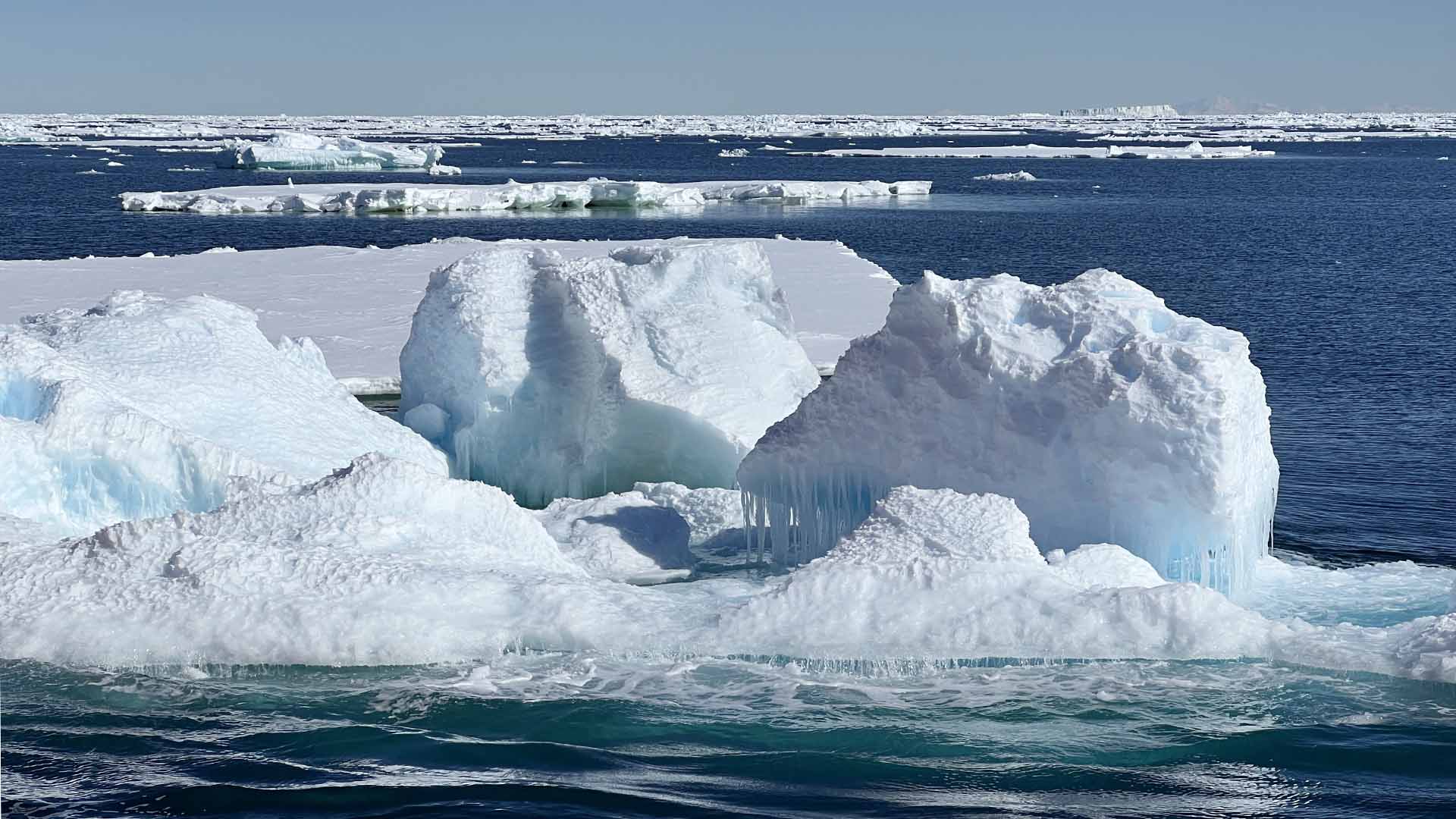 Photo of a large iceberg amidst the beautifully colored water
