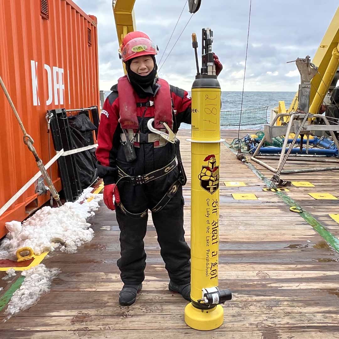 photo of crew member holding Sir Float a Lot on the deck of the ship