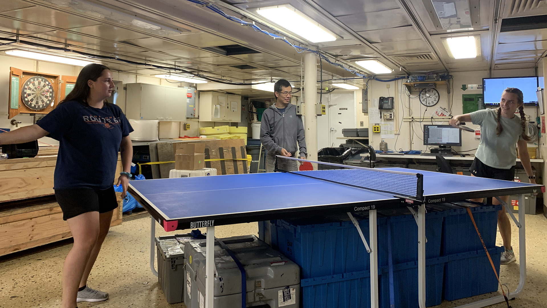 Bo Yang (center) giving Mackenzie Blanusa (left) and Riley Palmer (right) tips and tricks for playing ping pong. 