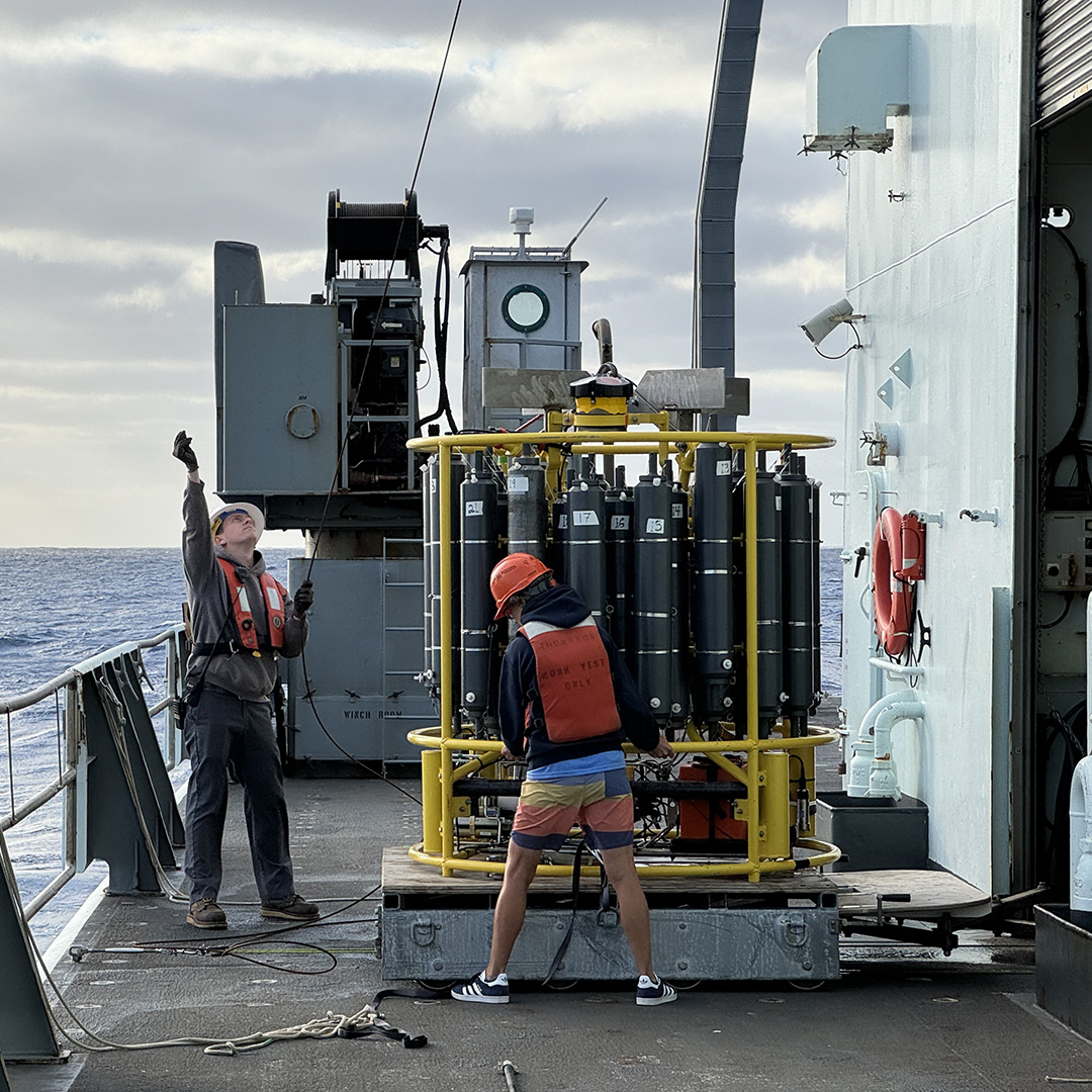 Marine Tech Emmett Dixon helps crew members maneuver the CTD into place on the platform.