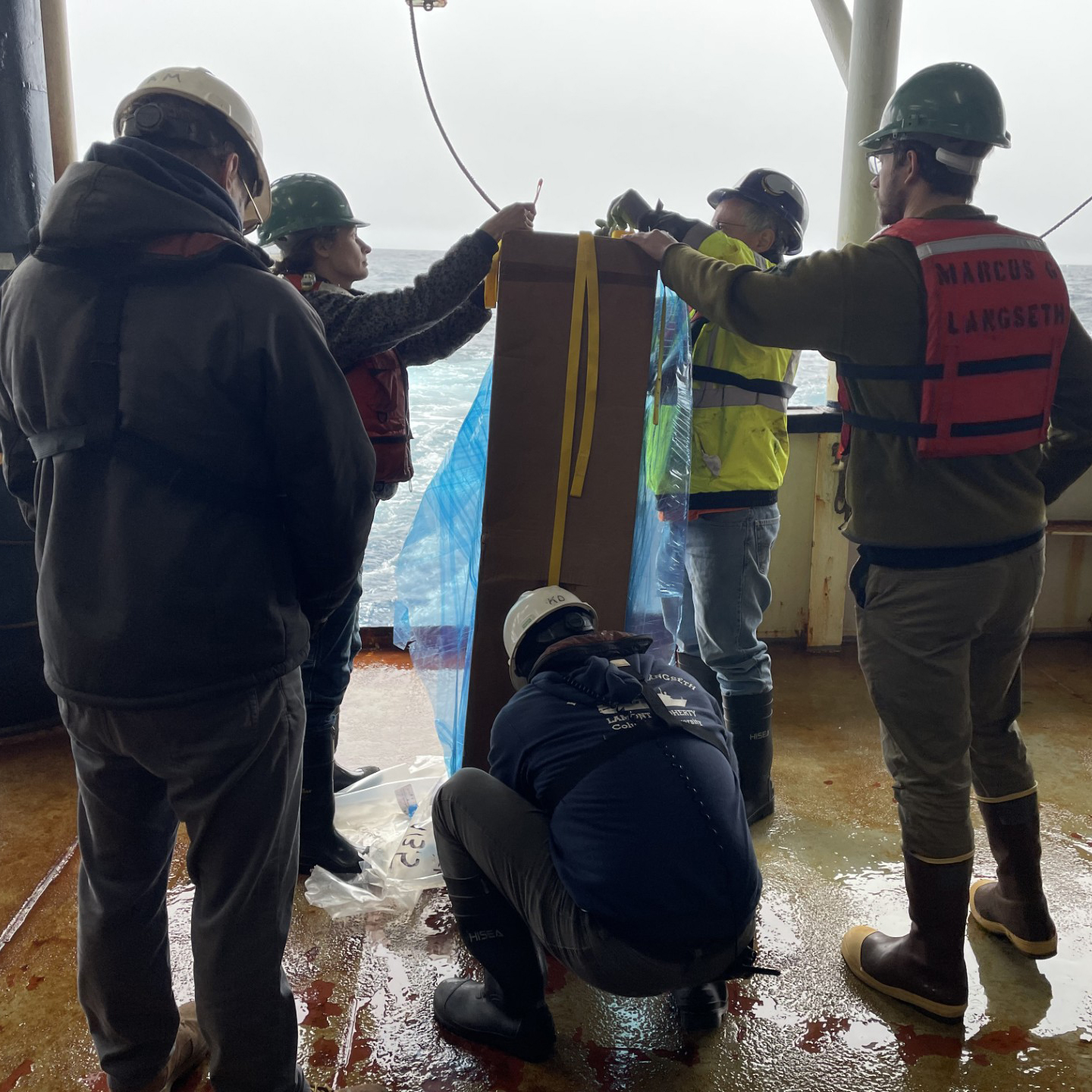 Todd Jensvold, Koray Ergun, and Aaron Martin assist Chief Scientist Zachary Erickson (NOAA PMEL) and Co-Chief Science Jesse Anderson (ESR) to prepare the Core Argo float for deployment off the stern of the Langseth.