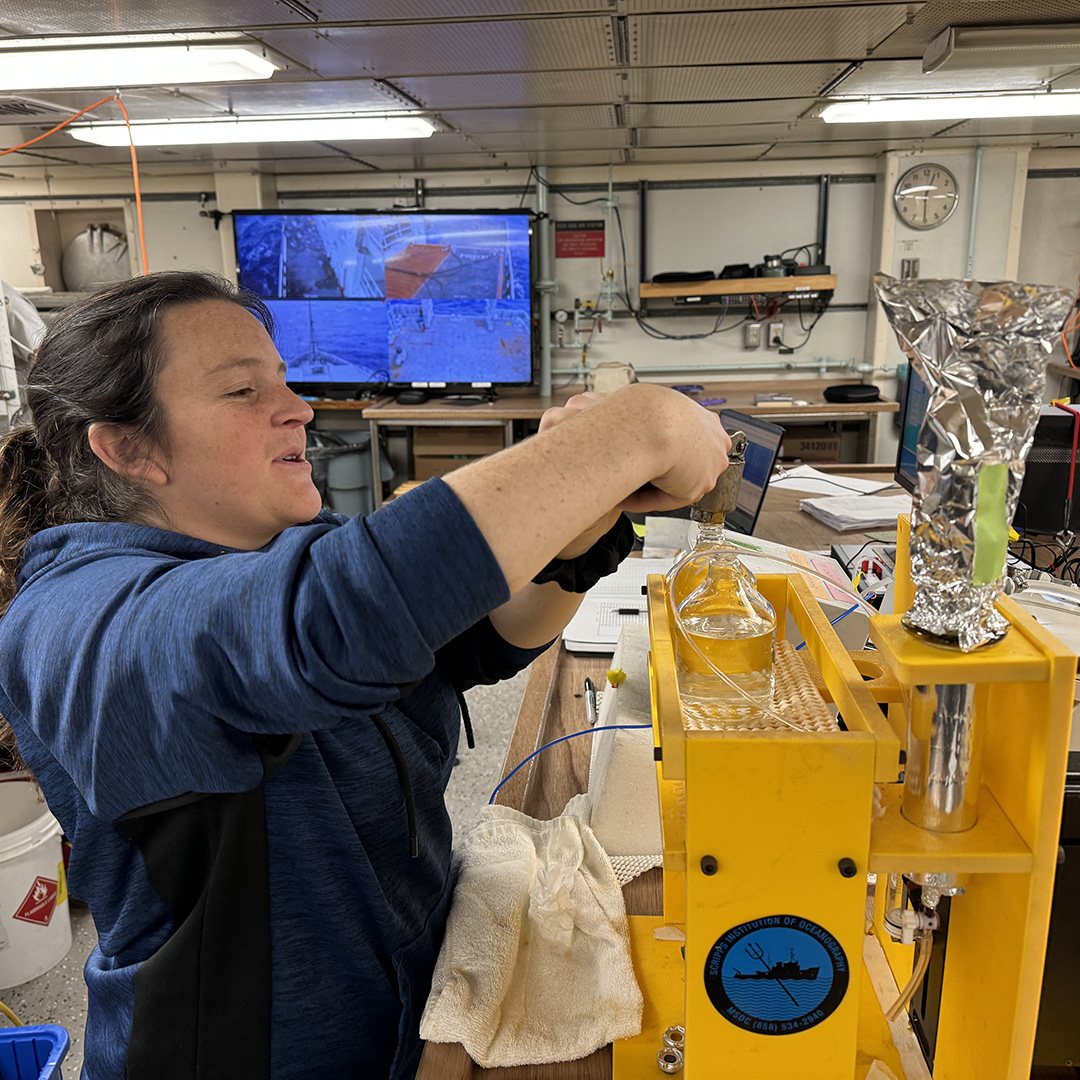 Abby uncrimps a sample bottle for processing in the spectrophotometer