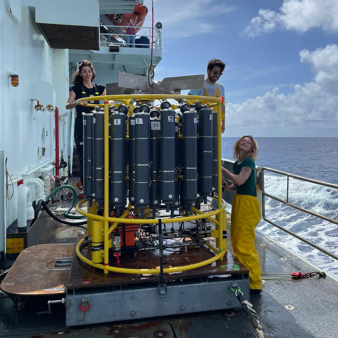 Ruth (far right) prepares the CTD on the deck of the R/V Thompson with fellow watchstanders Maria Sanchez Urrea (left) and Tatsu Monkman (center) (Photo by R. Bremer)