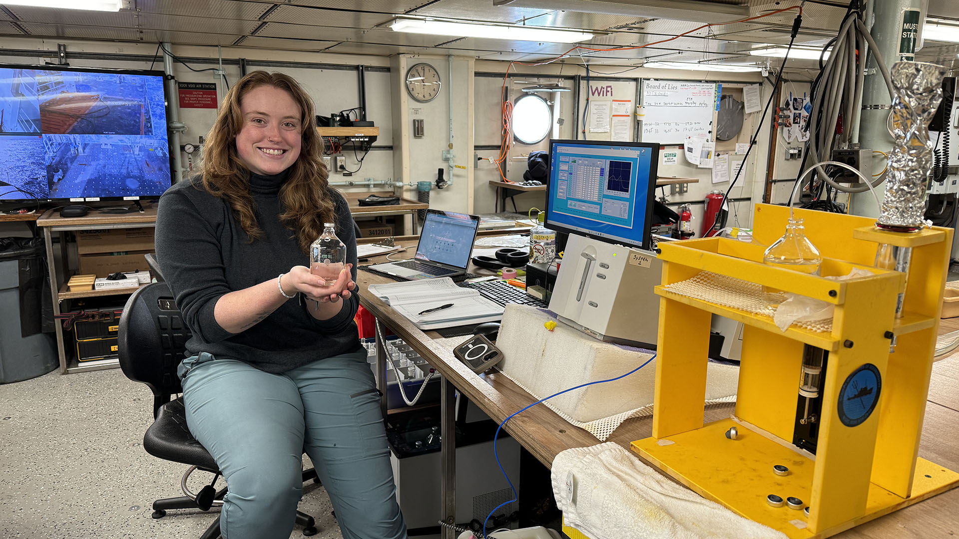 Cora sits at the pH analysis system onboard the R/V Thompson. Image by Jennifer Magnusson