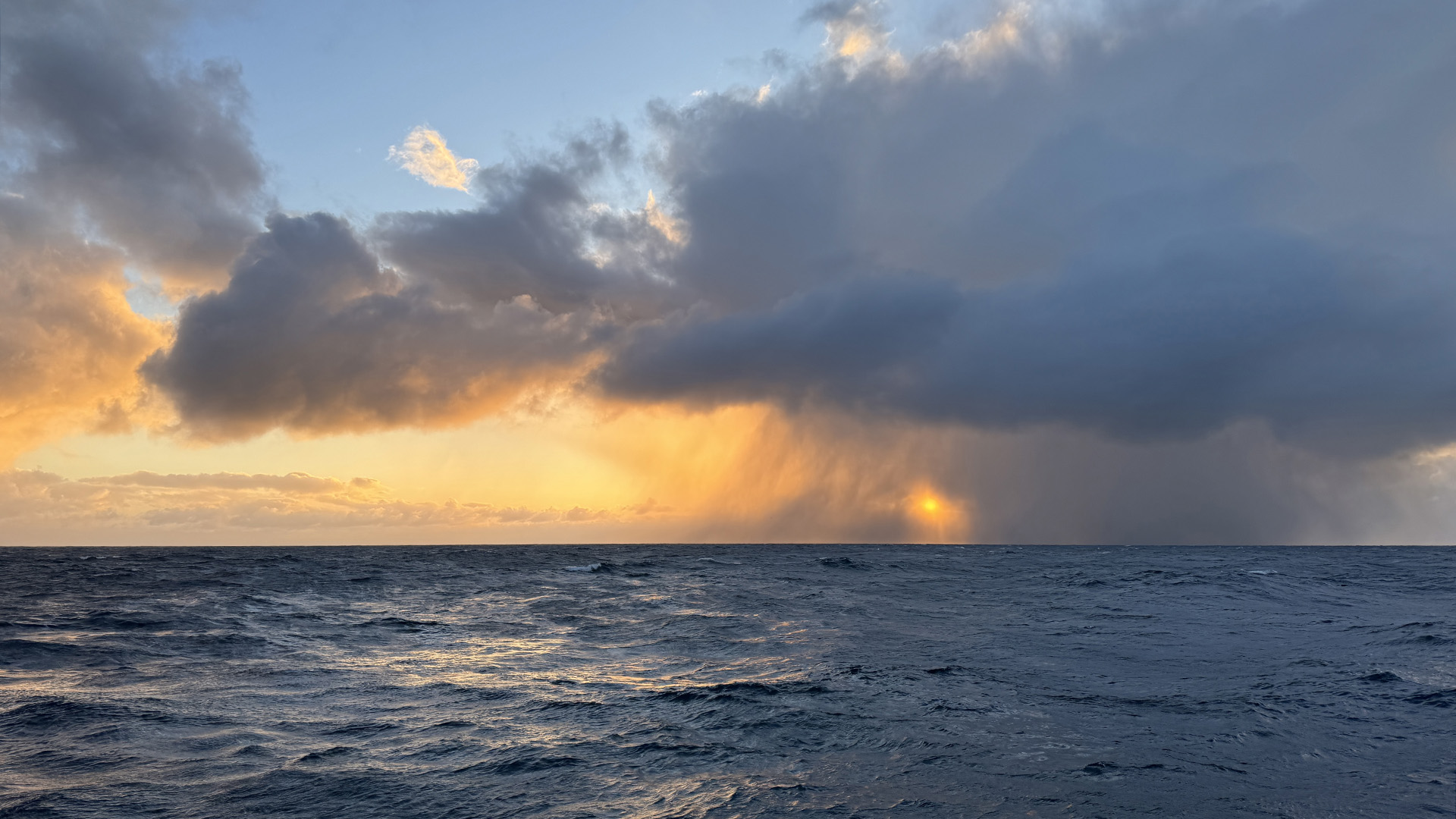 Another momentary shower veils the sunset over the Southern Ocean.